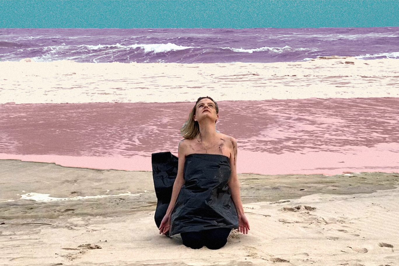 feminine figure wrapped in black cloth on a multicolored beach with smudges on their face